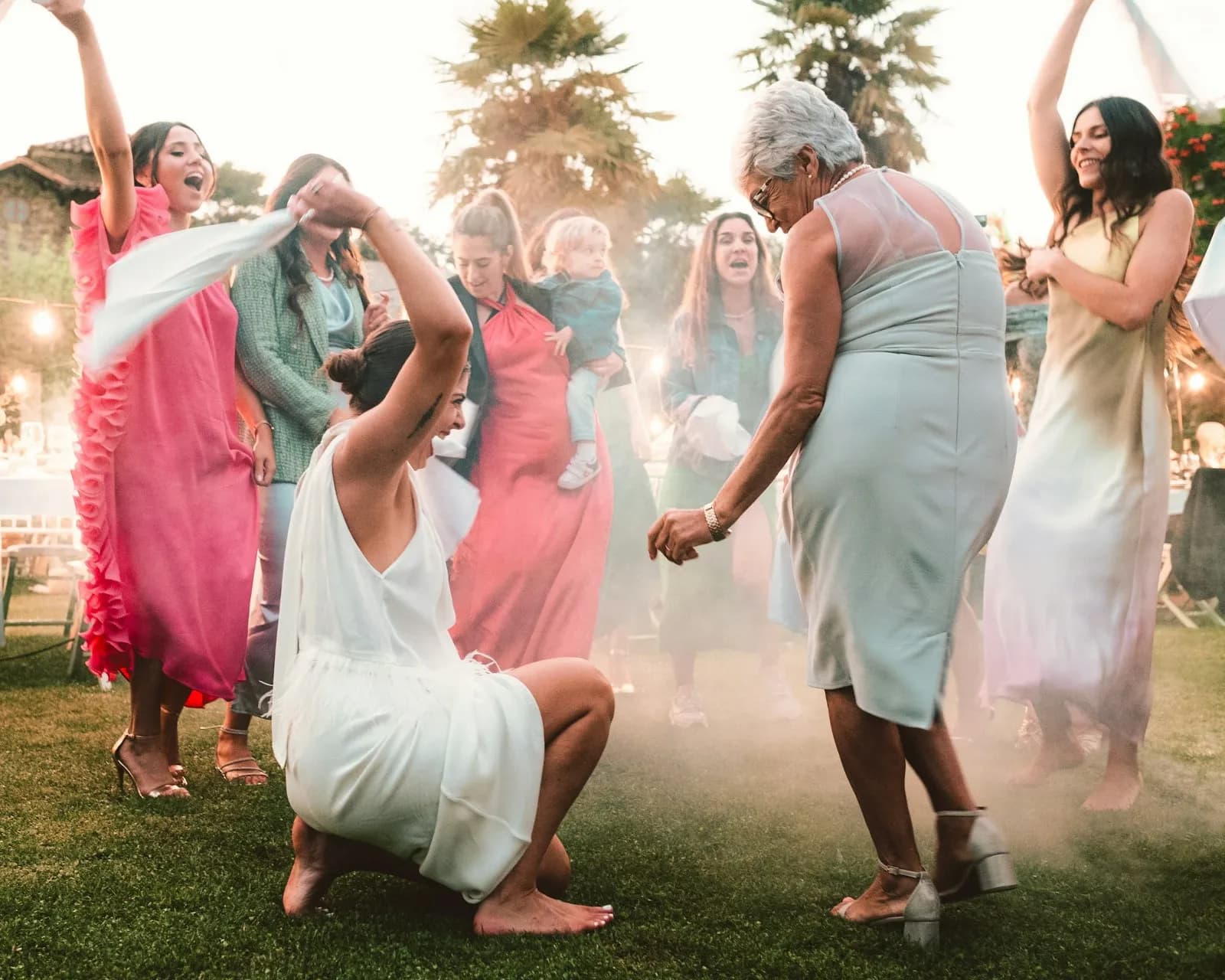 Wedding guests dancing joyfully outdoors in the late afternoon